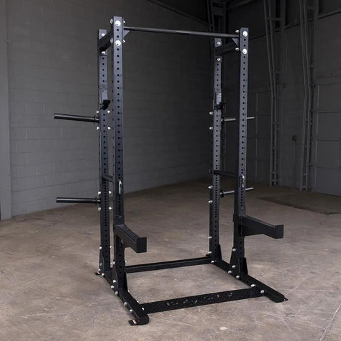 Tight Footprint Commercial Half Rack Package Featuring Olympic J Hooks Heavy Duty Spotter Bars And Weight Horns Beast Mode Strength Setup Built For Serious Deadlifts Squats Plus Daily Stretching Sessions In Matte Black, front view.