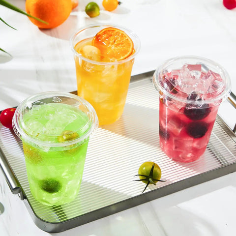 Three 16 oz clear plastic cups with lids on tray, filled with colorful iced drinks, showcasing 50 pack for iced coffee and cold drinks.
