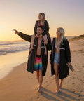 Family wearing Mens Waterproof Swim Parka With Hooded Poncho For Beach Or Pool, Oversized Changing Coat, walking on beach at sunset