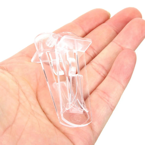 Hand holding a transparent clip from 24 Pack Plastic Locking Shelf Pegs For 19mm Thick Panels Self Locking Cabinet Clips
