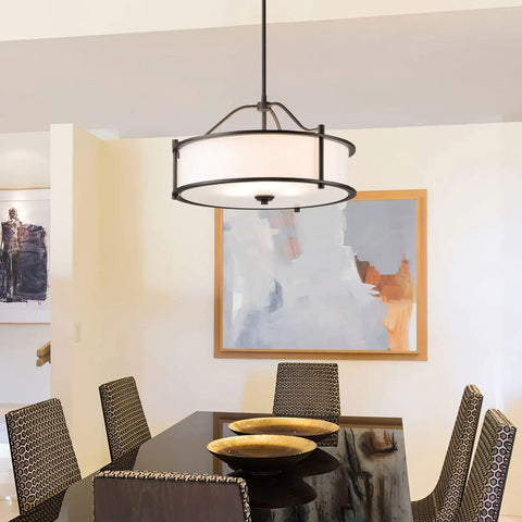 Dark Bronze 18 Inch 3 Light Drum Pendant with fabric shade and glass diffuser above dining table in modern living area.