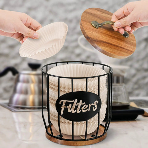 Rustic Coffee Filter Holder With Lid Built From Acacia Wood And Metal, showing filters being placed inside on a countertop.