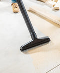 All Purpose Wet Dry Vac Attachment Kit For Home And Shop Use with floor brush in use on sawdust-covered floor