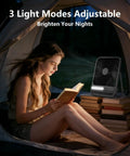 Woman reading in tent with Ultra Thin 7 Inch Portable Travel Fan Must Have With 8000mAh Battery, 28 Hours Runtime, Quiet Rechargeable Desk Fan
