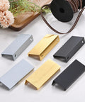 Six-Pack Aluminum Drawer Edge Pulls 3.15 Inch Concealed Tab Handles in brushed grey and other finishes on tabletop