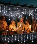 Dope Christmas Globe Curtain Lights 11.5Ft 96LED Crystal Ball Fairy Lights with people outdoors in evening setting