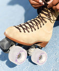 Person tying laces on roller skate with Two Pack LED Light Up Quad Roller Skate Wheels With Bearings For Indoor And Outdoor Skating