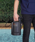 Person holding 1/3 HP Brushless Submersible Sump Pump with Auto Thermal Protector by a poolside.
