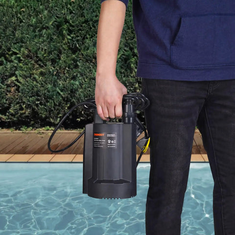Person holding 1/3 HP Brushless Submersible Sump Pump with Auto Thermal Protector by a poolside.