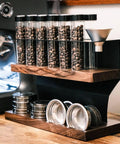 Two Tier Wooden Coffee Bean Storage Rack With Airtight Glass Jars Featuring Black Vent Lids Countertop Flex Freshness Sealer Brew Day Ready Kitchen Organization Set Keep Beans Crisp on wooden surface.