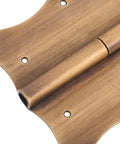 Close-up of vintage copper door and window hinges with decorative edges showcasing durability and smooth operation