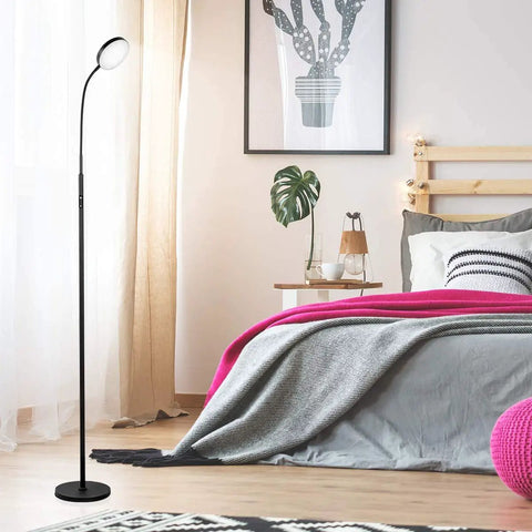 Modern Black LED Floor Lamp That Shines Brighter For Cozy Living Room Ambiance beside bed in minimalist bedroom setup