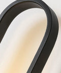 Close-up of the black curved arm of a Fresh Modern Glass Wall Sconce Lighting For Bedroom And Living Room Indoors Or Outdoors Creative Nordic Style Reading Lamp With Bright Led Bulbs For Dope Home Decor And Total Glow Up Night Vibes Tonight.