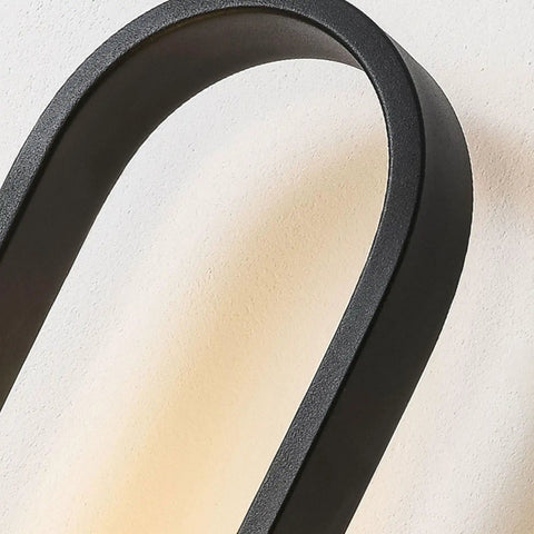 Close-up of the black curved arm of a Fresh Modern Glass Wall Sconce Lighting For Bedroom And Living Room Indoors Or Outdoors Creative Nordic Style Reading Lamp With Bright Led Bulbs For Dope Home Decor And Total Glow Up Night Vibes Tonight.