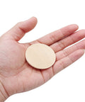 Sixty Pack Of Two Inch Natural Wood Slices Ideal For DIY Crafts And Seasonal Decor Unfinished round wood coin in hand.