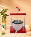 Heavy Duty 1.6 Gallon Stainless Steel Manual Press For Wine Cider Honey And Juicing Built Solid with red handles on a wooden base.