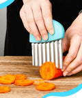 Two-piece blue stainless steel wave crinkle cutter set, close-up of carrot slicing on wooden board.
