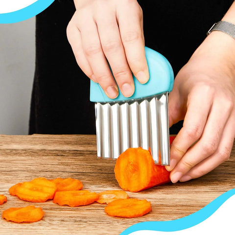 Two-piece blue stainless steel wave crinkle cutter set, close-up of carrot slicing on wooden board.