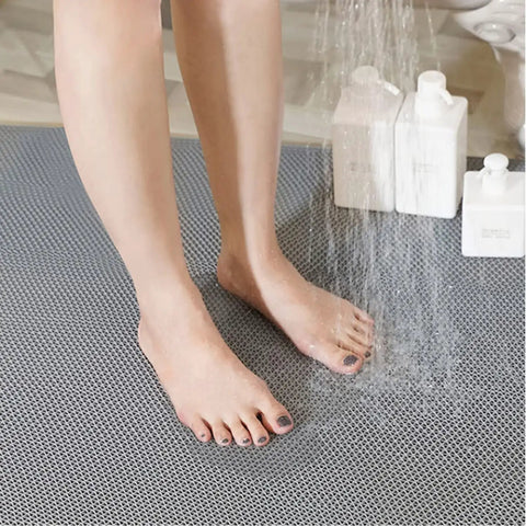 Person standing on Grippy Non Slip 3x10 Ft PVC Wet Floor Mat With Drainage For Indoor Outdoor Use Ideal For Restaurants Kitchens Bars And Pool Areas Durable Odorless Anti Slip Matting In Grey in a shower