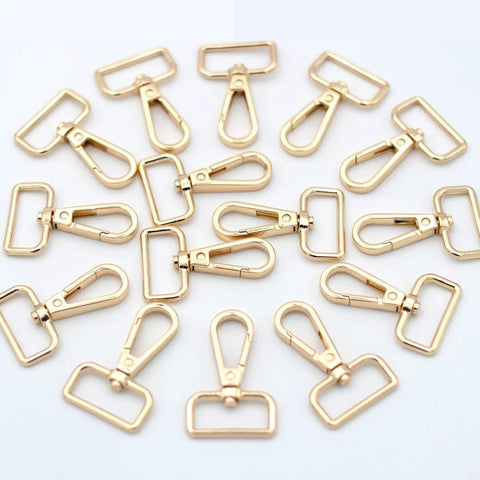 Hella Sturdy 15 Pack Solid Zinc Alloy D Ring Swivel Lobster Claw Clasp Hardware for Crafting Lanyards Bag Straps and Outdoor Gear Attachments Anti Rust Gold Finish, trigger clips arranged in a circular layout.