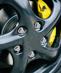 Five Piece Silver Steel Car Wheel Lug Nuts Set For Universal Tire And Rim Replacement on black alloy wheel close-up