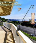 Rock Solid Heavy Duty Deck Rail Hook With 32 Inch Pole hangs bird feeders on a balcony railing, supporting 15 lbs for outdoor enjoyment.