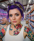Woman with tattoos wearing lavender opalite hollow glass ear plugs, shopping in a body jewelry store.