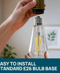 Person holding Vintage Edison Style WiFi Bulbs 2700K To 6500K Tunable White, Dimmable 8W LED showing E26 bulb base installation