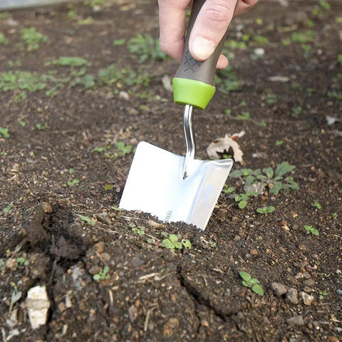 Hand using Stainless Steel Hand Trowel With Ergo Gel Grip 13 Inch Cushioned Comfort Handle for gardening in soil