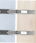 Front view of two HAKIDZEL folding cabinet hinge brackets in metal, mounted between blue and wood panels.