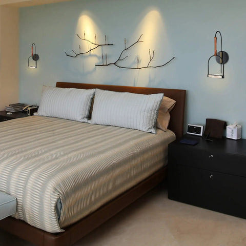 Bedroom with Ravenna 8 Inch Integrated LED Wall Sconce Lighting Fixture in black, above bed, soft white glow, modern design.