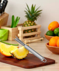 Sliced pineapple with V Shaped Stainless Steel Pineapple Eye Cutter And Remover Tool For Home Kitchen on cutting board