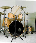 Straight Up Adjustable Height Alloy Snare Stand With Folding Practice Pad Rack black metal stand holding a snare drum with drumsticks.