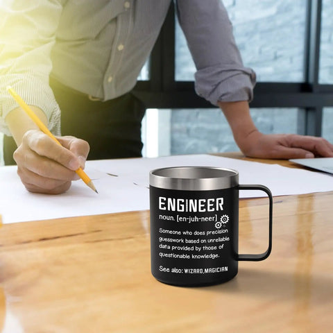 Engineer Definition Insulated Coffee Mug 12 Oz For Engineers Gift For Men Black Perfect Christmas Birthday Gift For Engineering Students And Pros Who Love Their Brew Gift Idea on desk with person writing in background