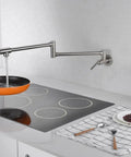 Pot Filler Faucet Wall Mount Brushed Nickel Finish With Dual Swing Joints filling a pan on a stove in a modern kitchen.