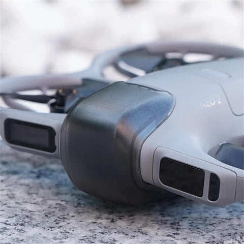 Drone Lens Cover Set For DJI NEO 2, 2 Pack Gimbal Protector Caps, attached to a NEO 2 drone on a stone surface