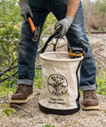 Worker using Canvas Tool Bucket With Drain Holes, Heavy Duty Canvas Pail For Tools And Gear, Plastic Bottom, 150 Pound Load Rating