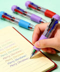 Hand writing in notebook with four-color pen from Bulk Stationery Gift Set With 24 Four In One Retractable Pens Multi Color Inks 24 Mini Notebooks And 24 Organza Bags For Corporate Events And Teacher Appreciation Ideal Office Supplies.