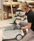 Person placing a Reusable Dust Bag For Festool Cleantec CTL CTM Series Vacuums CT26 CT36 CT48 in a vacuum in a workshop.