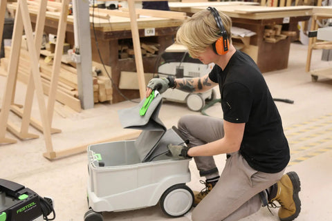 Person placing a Reusable Dust Bag For Festool Cleantec CTL CTM Series Vacuums CT26 CT36 CT48 in a vacuum in a workshop.