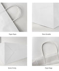 Close-up of white kraft paper bags with handles, showcasing durability, reinforced edges, and paper rope handles.