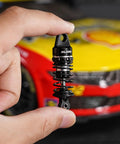 Person holding a 45mm Oil Shock With Progressive Rate Springs for One Twelfth Losi Nascar RC, showing CNC machined aluminum body.