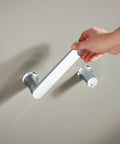 Hand installing the Genta LX Modern Wall Mount Pivoting Toilet Paper Holder in Chrome for Bathroom Easy Install Slick Chrome Toilet Roll Holder