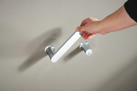 Hand installing the Genta LX Modern Wall Mount Pivoting Toilet Paper Holder in Chrome for Bathroom Easy Install Slick Chrome Toilet Roll Holder