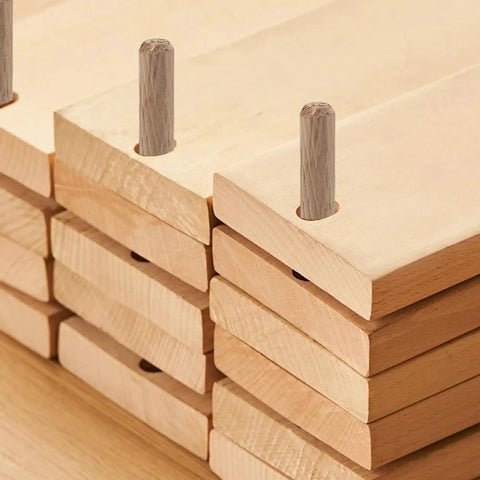100 Pack Wooden Dowel Pins 8X30MM Hardwood Twist Groove Pegs With Tapered Ends installed in predrilled holes of stacked wood pieces.