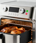 Stainless steel air fryer oven with digital controls cooking meat on a tray