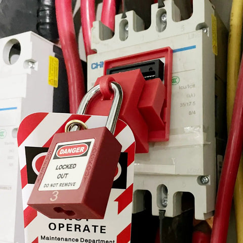Universal 480/600V Circuit Breaker Lockout Devices Set With LOTO Tags in use on electrical panel, securing breaker.