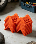 Orange 20 Pack Plastic Flatbed Edge And Corner Protectors For Trucks stacked in a garage with tools in the background.