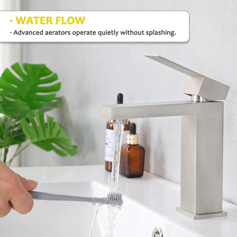 Hand using Brushed Nickel Bathroom Faucet With Cross Handles, Antique Vintage Style, 4 Inch Centerset Sink Faucet For 2 Or 3 Hole Vanities, No Fuss Install, Great For RV Camper Lavatory And Home Bath to rinse toothbrush in modern bathroom setting.