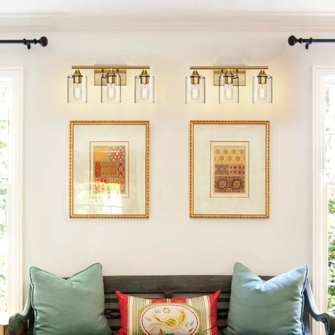 Three Light Vanity Light Fixtures Matte Black Finish With Clear Glass Shades above framed artwork in living room